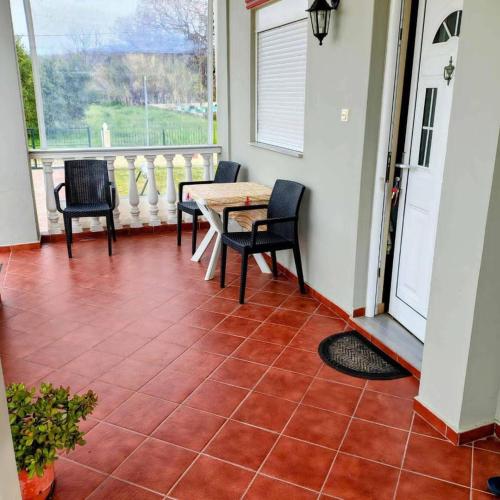 a patio with a table and chairs on a porch at Olive Tree Villa in Preveza