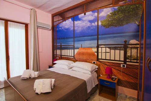 a bedroom with a large window with a view of the ocean at Hotel Roma in Pineto