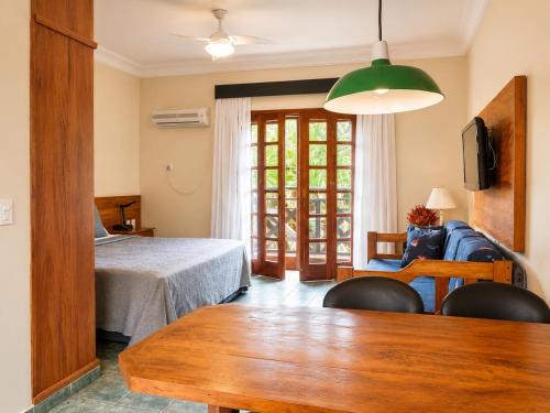 a living room with a bed and a table at Suíte 1210 Ilhaflat in Ilhabela