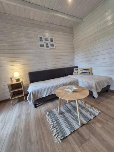 a bedroom with a bed and a table in it at Holiday Resort Zakątek Łeba in Łeba