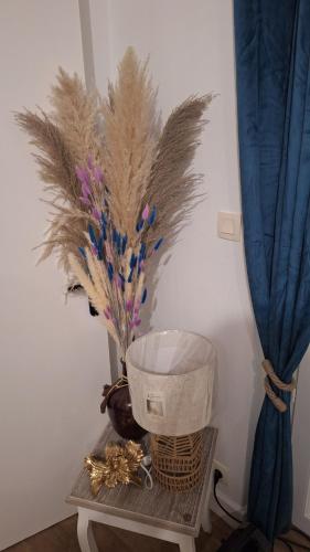 a table with a basket and a vase with feathers at Libre comme l'air - Appartement - Terrasse - 1 Chambre in Ruffec