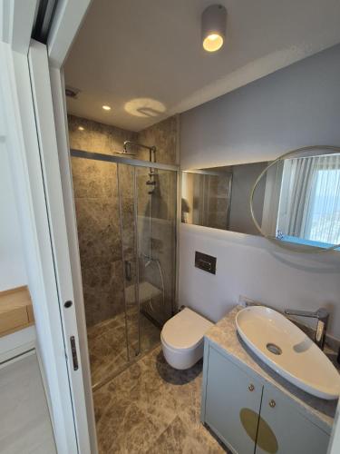 a bathroom with a shower and a toilet and a sink at Helis Bodrum Residence in Milas