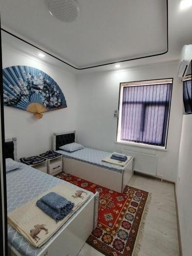 a room with two beds and a window at KAMIR Guest House in Bukhara