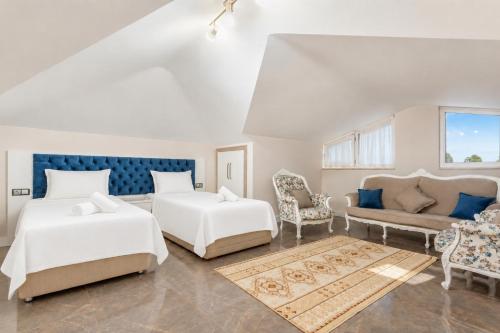 a bedroom with two beds and a couch at Villa Ozcelik in Dalyan