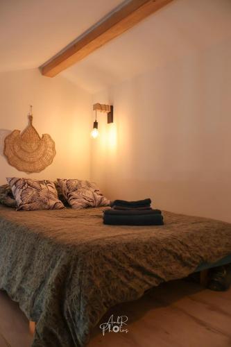a bedroom with a bed with two pillows on it at Chalet tous confort avec piscine lagon in Vallon-Pont-dʼArc