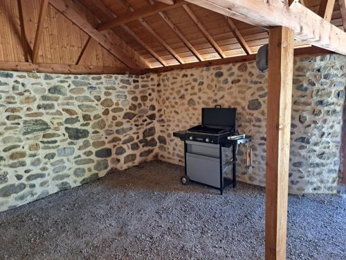 a small stove in a room with stone walls at le Cocon in Montgardin