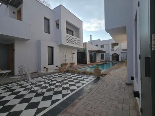 a house with a checkered floor and a swimming pool at Stipa Boutique Hotel in Chacras de Coria
