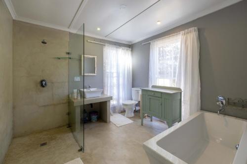 a bathroom with a tub and a sink and a shower at 30 on Oatlands Accommodation Makhanda Grahamstown in Grahamstown