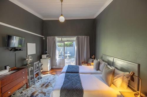 a bedroom with a large bed and a television at 30 on Oatlands Accommodation Makhanda Grahamstown in Grahamstown