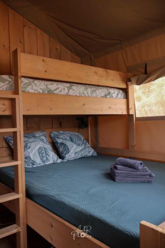 a bedroom with two bunk beds in a cabin at Tente chauffée avec piscine lagon in Vallon-Pont-dʼArc