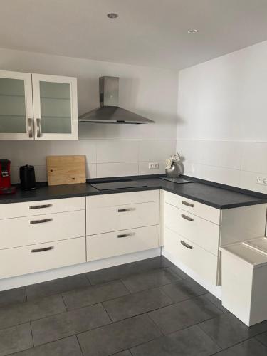 a kitchen with white cabinets and a black counter top at Ferienwohnung Weitblick in Rodalben