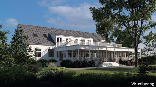 a large white house with a gambrel roof at Margretes Badhotell in Strandbaden