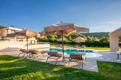 a patio with chairs and umbrellas and a pool at Kallies villas with shared Pool in Pefkochori