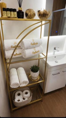 a towel rack with towels and a sink in a bathroom at S-Penthouse in Herceg-Novi