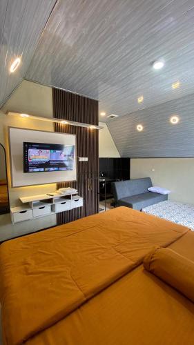 a bedroom with a bed and a flat screen tv at villa cabin vianda in Kejajar