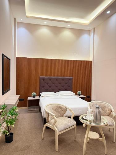 a bedroom with a large bed and two chairs at The Lamendriea Hotel in Kalagedihena