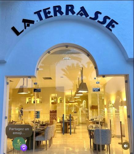 a store window with tables and chairs in it at Suites Hôtel Les Charmilles & Spa in Tunis