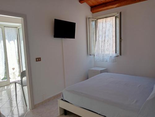 a bedroom with a bed and a tv on the wall at Antares in Isnello