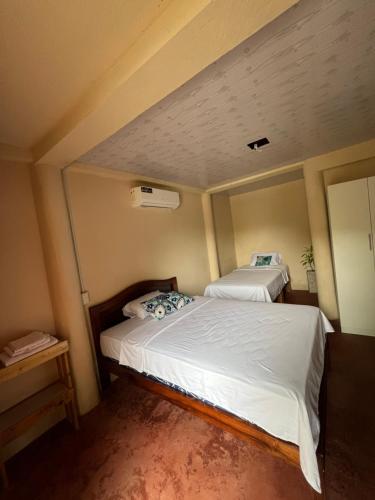 two beds in a small room with a ceiling at Raimy Sumaq in Arenillas