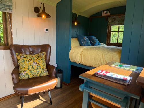a bedroom with a bed and a chair and a table at The Drey in Trelleck