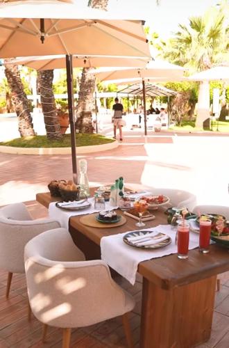 a table with food on it under an umbrella at Suites Hôtel Les Charmilles & Spa in Tunis