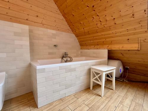 a bath tub in a room with a wooden ceiling at U Marcjana in Kamienica Królewska
