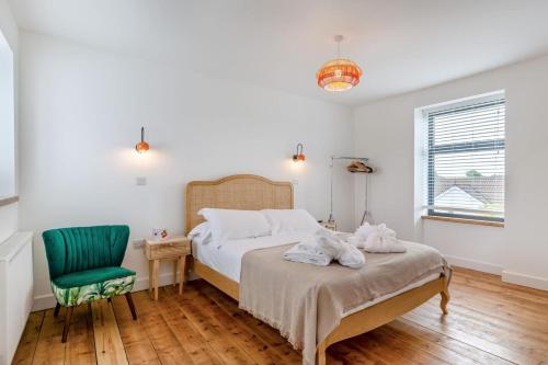 a bedroom with a bed and a green chair at 4 Bed in Bugle oc-f34175 in Penwithick