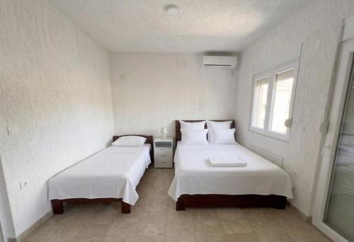 a small room with two beds and a window at Elit Apartmani in Ulcinj
