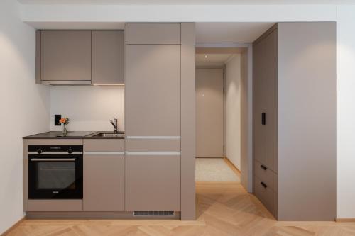 a kitchen with white cabinets and a stove at ODA Suites - self check-in apartments, old town in Lucerne