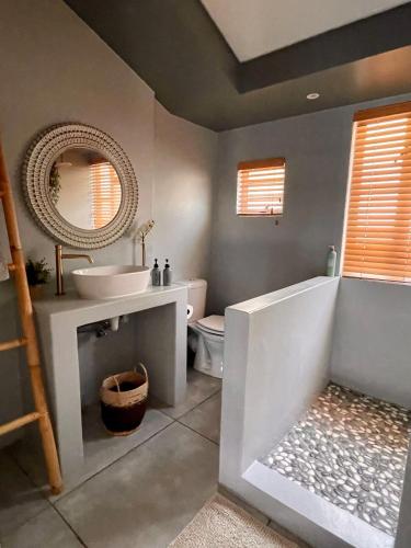 a bathroom with a sink and a tub and a mirror at The Kite Cottage in Langebaan