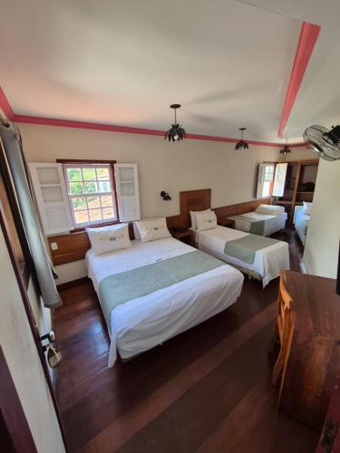 a bedroom with three beds in a room at Pousada dos Bandeirantes in Ouro Preto