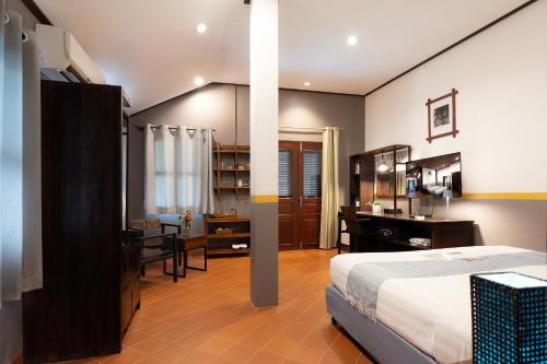 a bedroom with a bed and a desk and a table at Sanctuary Hotel Luang Prabang in Luang Prabang