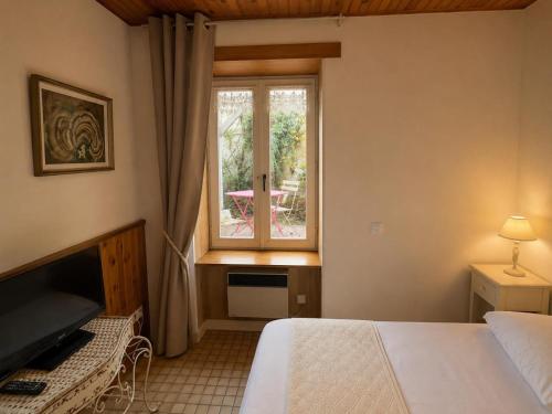a bedroom with a bed and a window at Aux Roses in Saint-Honoré-les-Bains