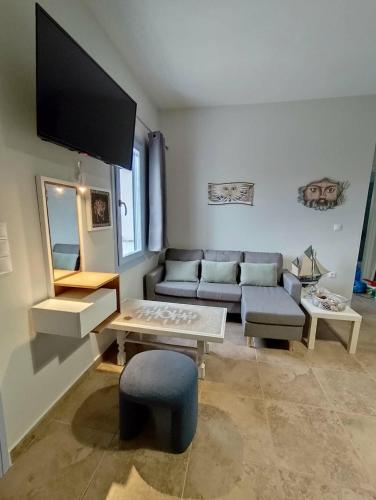 a living room with a couch and a table at Mosaic house by the sea in Kini