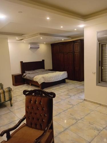 a bedroom with a bed and a chair in a room at شاليهات الشهد والحلا in Amman