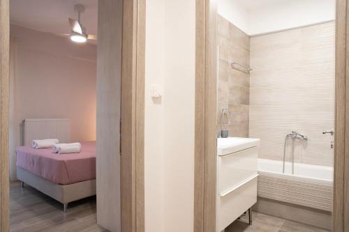 a bathroom with a bed and a tub and a sink at Boheme Apartment in Leptokarya