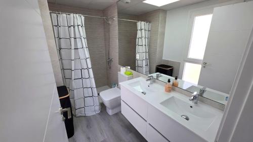 a bathroom with a sink and a toilet and a mirror at Chalet Laguna Place in Chipiona