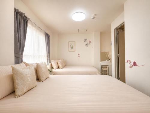 a bedroom with two beds and a window at 幸・3 in Osaka