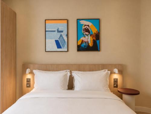 a bedroom with a bed and three paintings on the wall at Numa Brighton Pavilion in Brighton & Hove