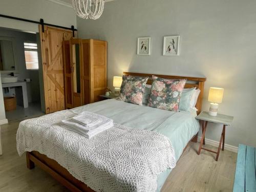 a bedroom with a bed and two lamps and a bed sidx sidx sidx at The Kite Manor in Langebaan