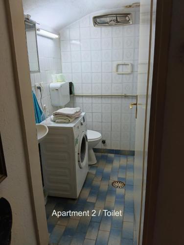 a bathroom with a washing machine and a toilet at 10Forward apt2 in Bitola