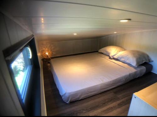 a bed in the back of a boat at Tiny House avec jacuzzi privé - calme et nature in Grabels