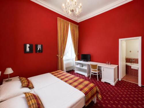 a red bedroom with two beds and a desk at Park Hotel Tartuf in Beladice