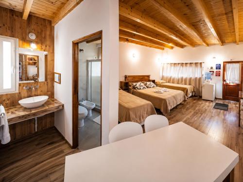 a hotel room with a bedroom and a bathroom at Raíces in Puerto Pirámides