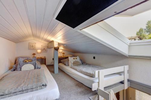 a attic bedroom with two beds and a vaulted ceiling at Ferienhaus Hennesee in Meschede