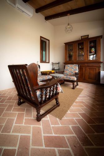 a living room with two chairs and a table at Casale Rûsignul in Cassegliano