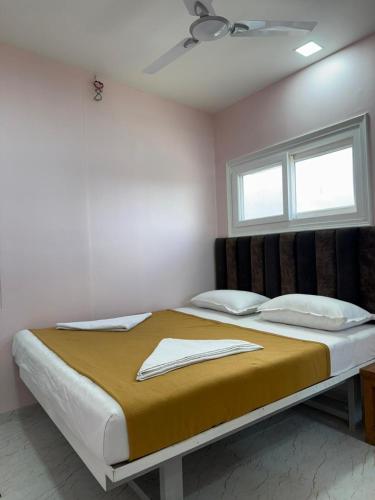 a large bed in a room with a window at Chandralok Service Apartments in Kolhapur