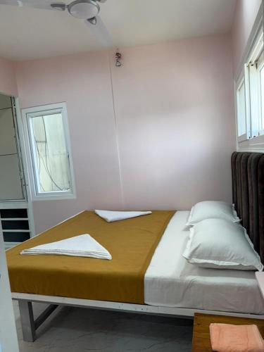 a large bed in a room with a window at Chandralok Service Apartments in Kolhapur