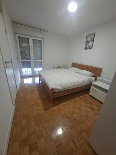 a bedroom with a bed and a wooden floor at Apartman Mirjana 2 spavace odvojene sobe in Banja Luka