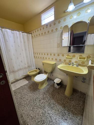 a bathroom with a toilet and a sink and a mirror at La Mary duplex in Federación